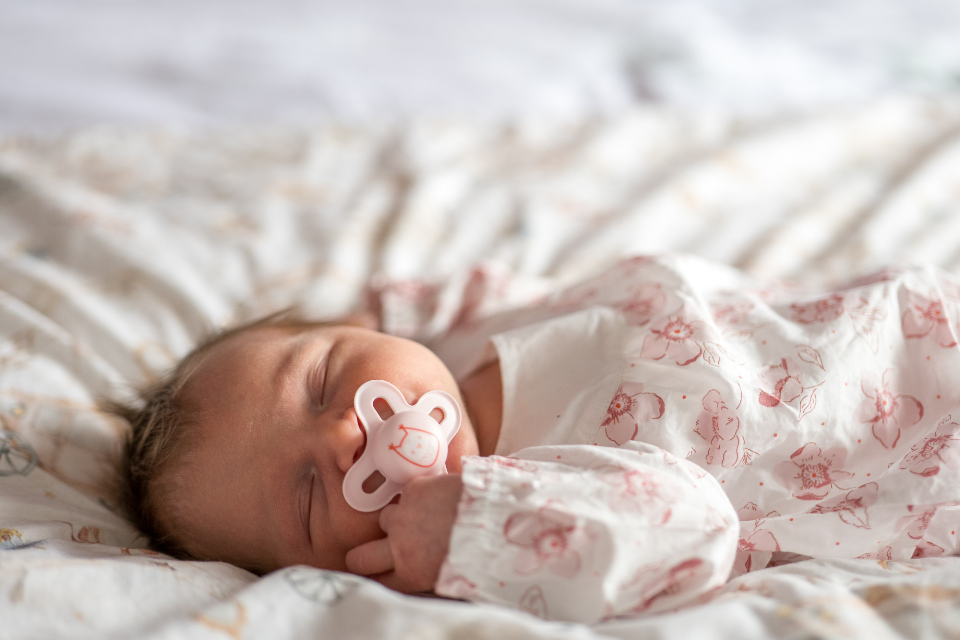 Rêveuse d'étincelles - Tatiana MAURINES - Photographe et biographe sur Écully, Lyon et la région Rhône-Alpes. Photographe à écully, cette image représente un nouveau-né dormant sur un lit avec sa tétine.