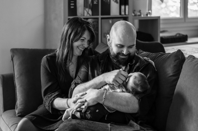 Rêveuse d'étincelles - Tatiana MAURINES - Photographe et rédactrice sur Écully, Lyon et la région Rhône-Alpes. Photographe de grossesse à Lyon, cette séance a été réalisée à domicile. Deux jeunes parents regardent leur nouveau-né.