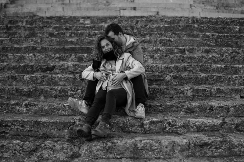Rêveuse d'étincelles - Tatiana MAURINES - Photographe et rédactrice sur Écully, Lyon et la région Rhône-Alpes. Photographe de grossesse à Lyon, cette séance a été réalisée en extérieur, sur les marches en pierre d'un monument. Un couple entoure de leurs mains le ventre rond de la femme enceinte.