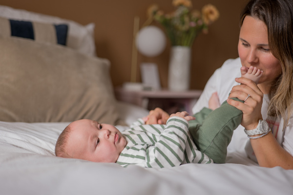 Rêveuse d'étincelles - Tatiana MAURINES - Photographe et rédactrice sur Écully, Lyon et la région Rhône-Alpes. Séance photo de famille à Lyon. Une maman joue avec son fils sur le lit.